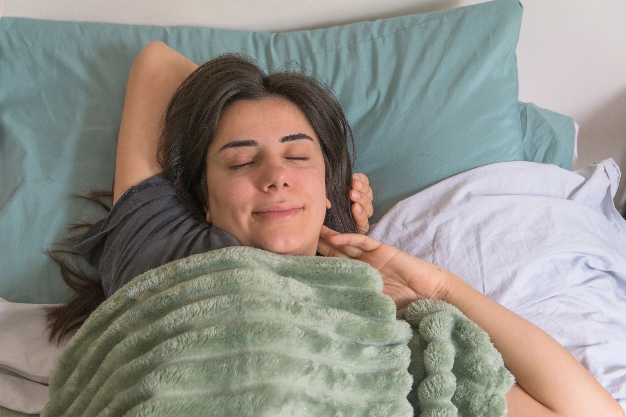 Relaxed customer resting comfortably under a soft blanket